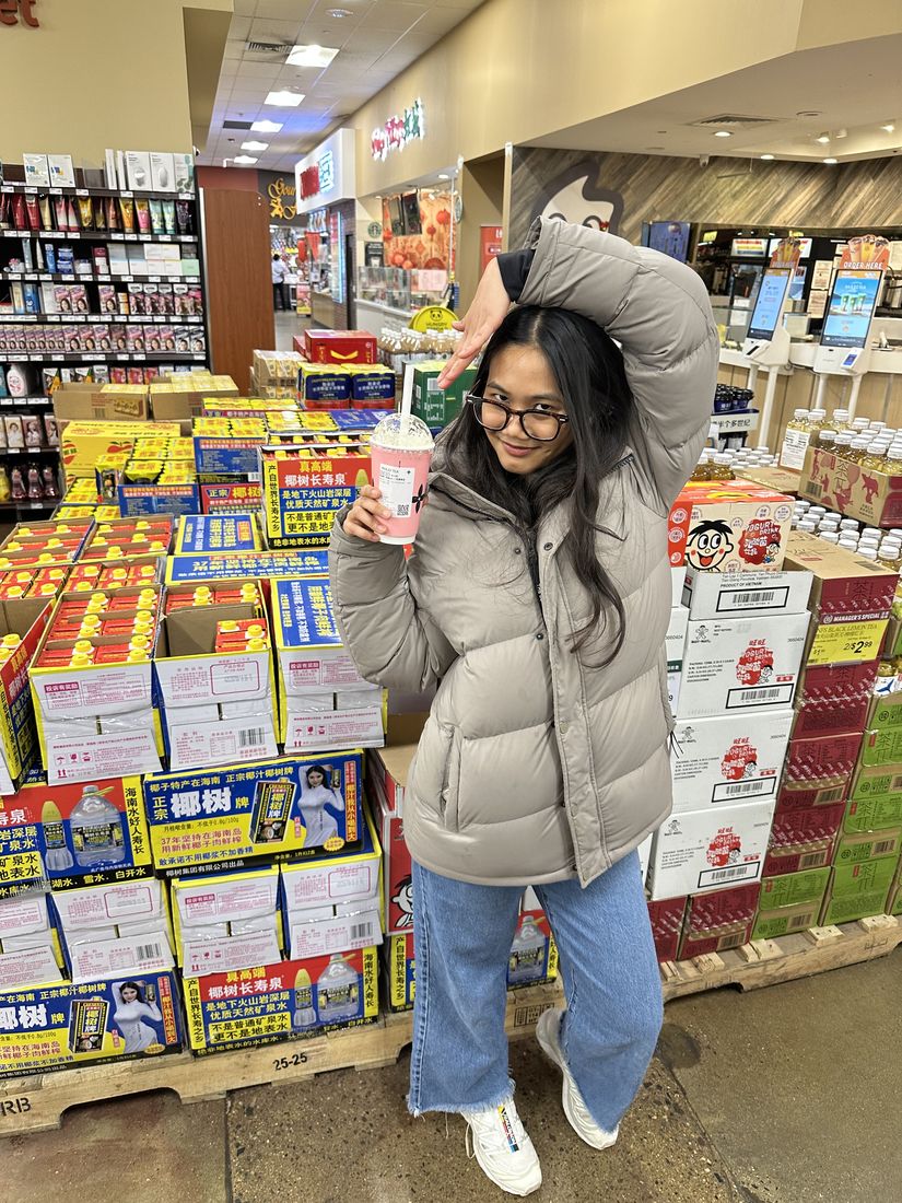 Yas holding a pink drink in a grocery store