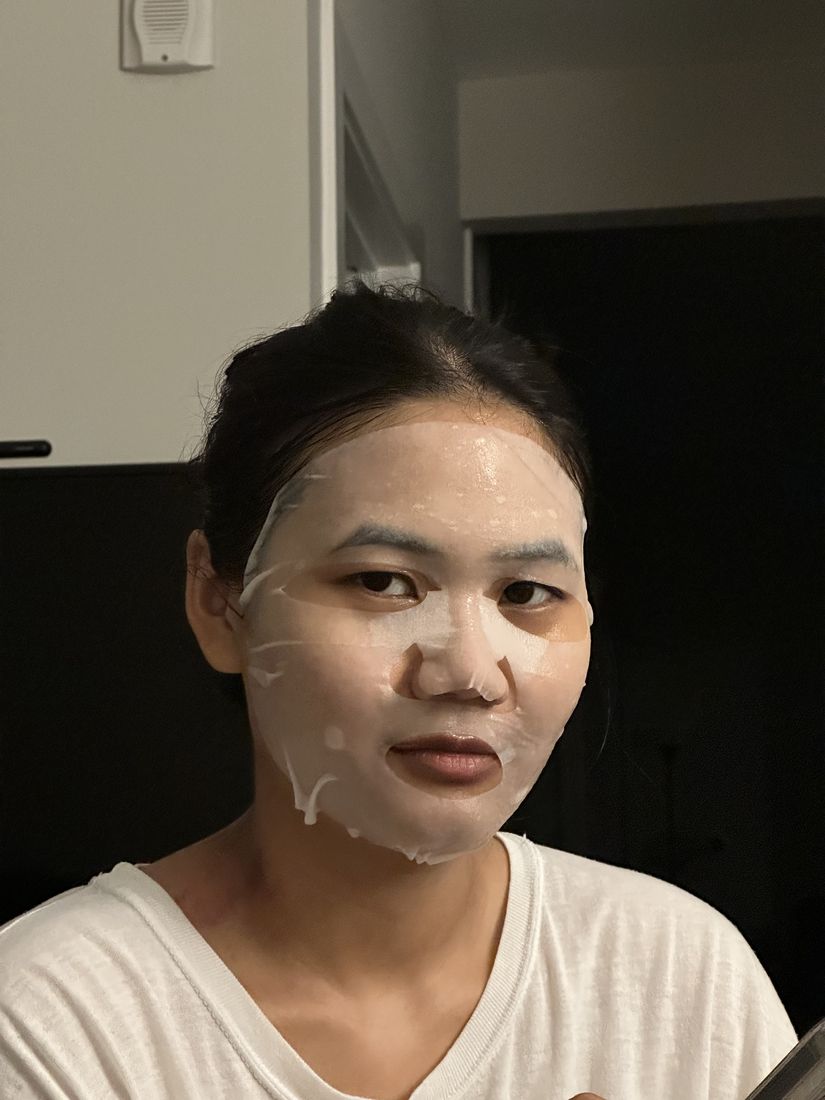 Yas wearing a white sheet face mask, smiling