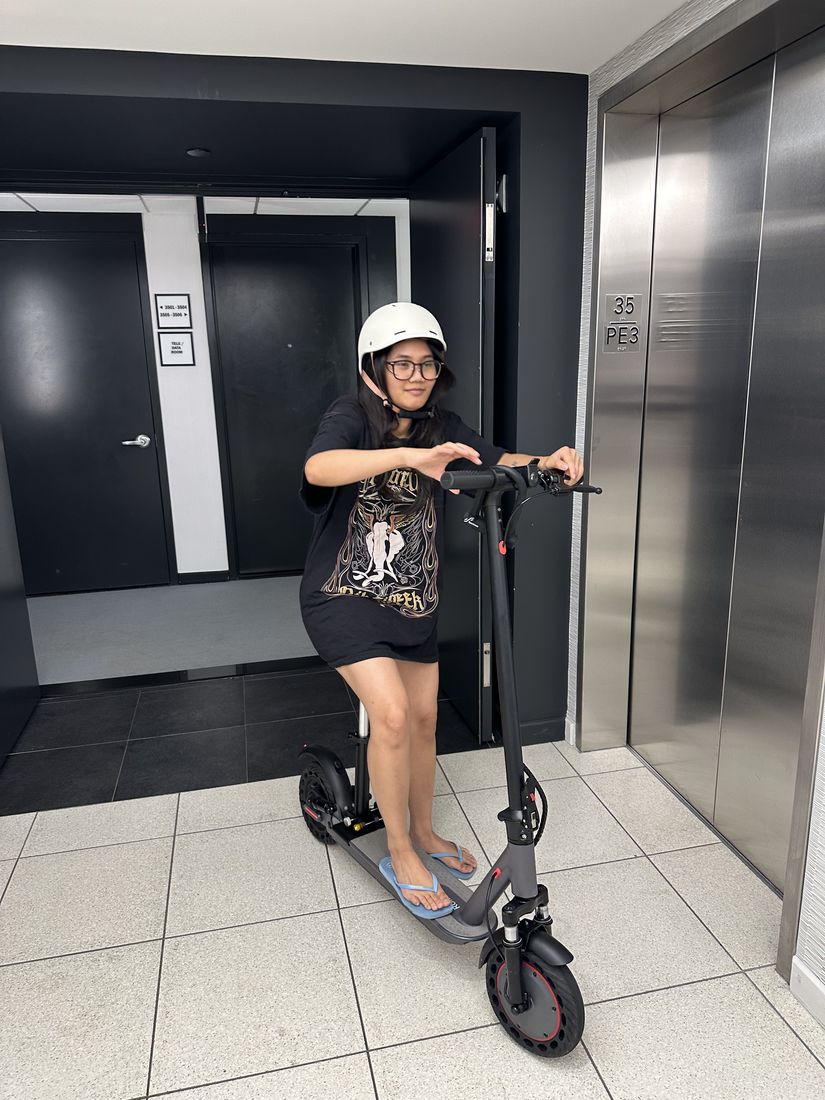 Yas on a scooter wearing a white helmet